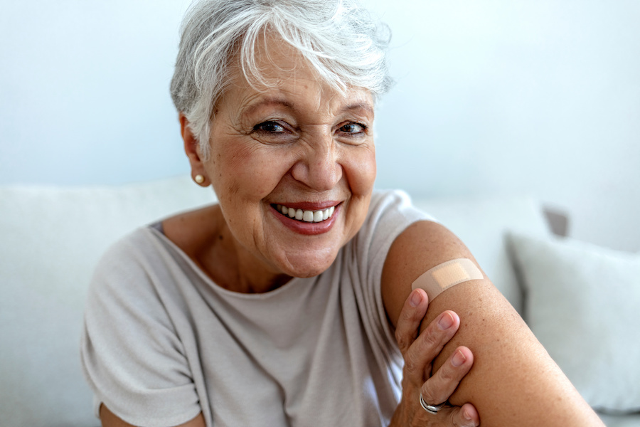 smiling lady with her band-aid, happy to be protected