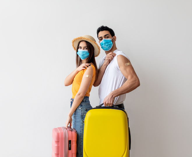 a traveling couple showing their band-aid portraying they have all their required vaccinations