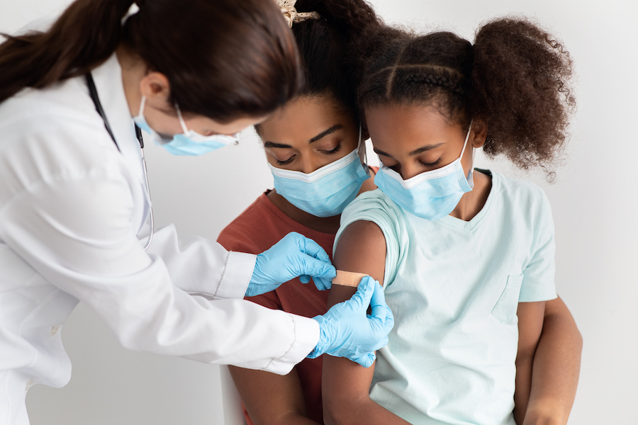 woman holding child that is getting vaccinated